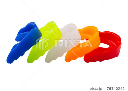 many multi-colored boxing mouth guards, lie in a row, on a white background many multi-colored boxing mouth guards, lie in a row, on a white background 76340242