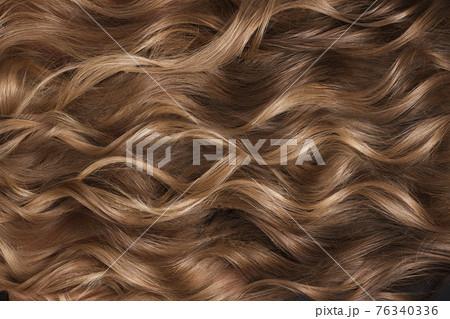A closeup view of a bunch of shiny curls blond hair 76340336