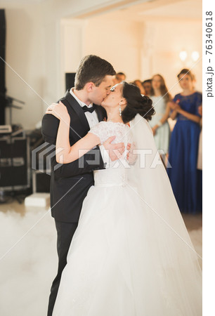 Beautiful caucasian wedding couple just married and dancing their first dance Beautiful caucasian wedding couple just married and dancing their first dance 76340618
