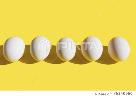 White fresh eggs in line on yellow background. 76340960
