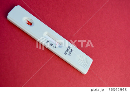 test for coronavirus lies on a red background. white test strip on a bright background to determine the infection. sensitive test for coronavirus antibodies test for coronavirus lies on a red background. white test strip on a bright background to determine the infection. sensitive test for coronavirus antibodies 76342948