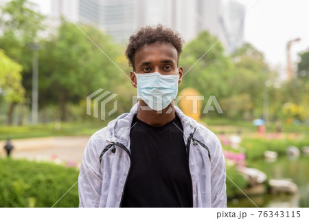 Portrait of handsome black African man wearing face mask 76343115