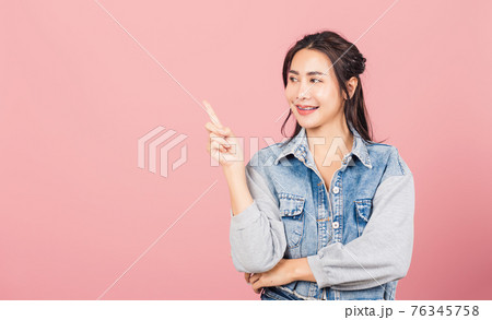 woman standing smiling indicate finger empty space 76345758
