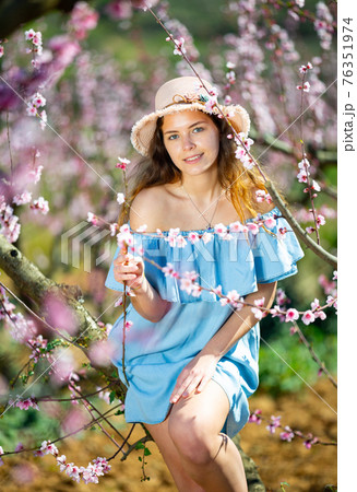Girl in the spring garden peach in blue dress and hat Girl in the spring garden peach in blue dress and hat 76351974