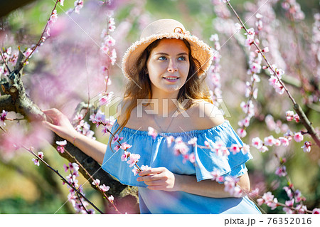 Girl in the spring garden peach in blue dress and hat 76352016