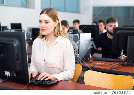 Portrait of female and male students working on computers in classroom Portrait of female and male students working on computers in classroom 76352876