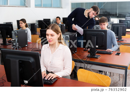 Positive female student works at computer Positive female student works at computer 76352902