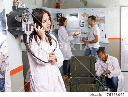 Girl using telephone set in escape room 76353065