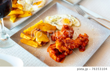 Spicy chicken with baked potato and fried egg Spicy chicken with baked potato and fried egg 76353104
