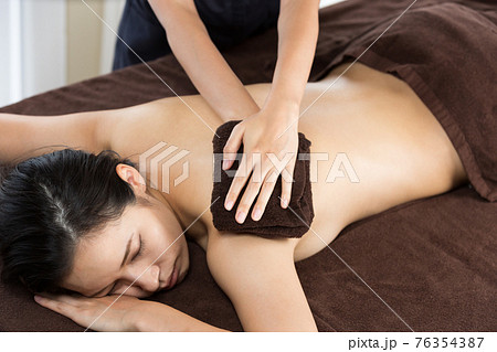 タオルで背中を拭く女性 76354387