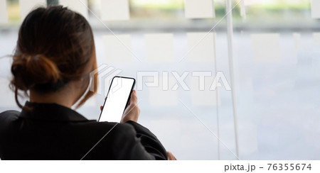Close up business woman using smart phone with white blank screen at office 76355674
