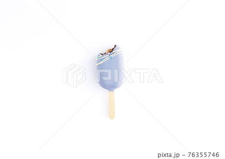 Isolated bitten blue cookie ice cream on a stick on white background Isolated bitten blue cookie ice cream on a stick on white background 76355746