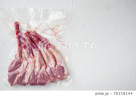 Lamb ribs for sous vide cooking in plastic vacuum package, on white stone background, top view flat lay , with copyspace and space for text 76358144