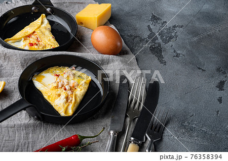 Fried breakfast omelette with crab meat and cheese, on frying iron pan, on gray background , with copyspace and space for text Fried breakfast omelette with crab meat and cheese, on frying iron pan, on gray background , with copyspace and space for text 76358394
