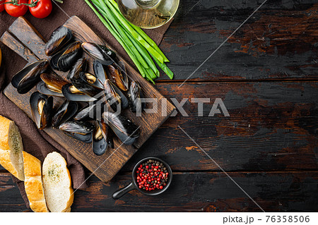 Mussels, molluscs, seaweed, sea plants with spices, on wooden cutting board, on old dark wooden table background, top view flat lay , with copyspace and space for text Mussels, molluscs, seaweed, sea plants with spices, on wooden cutting board, on old dark wooden table background, top view flat lay , with copyspace and space for text 76358506
