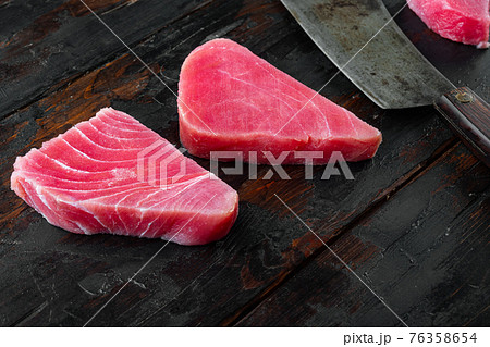 Raw organic tuna fillet. Seafood, and old butcher cleaver knife, on old dark wooden table background 76358654