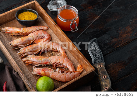 Raw red Argentinian prawns, in wooden box, on old dark wooden table background , with copyspace and space for text 76358655
