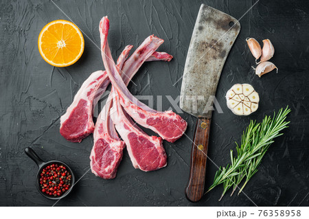 Organic pieces of mutton meat, Rack of lamb , raw with bone, with ingredients carrot orange, herbs, on black stone background, top view flat lay Organic pieces of mutton meat, Rack of lamb , raw with bone, with ingredients carrot orange, herbs, on black stone background, top view flat lay 76358958