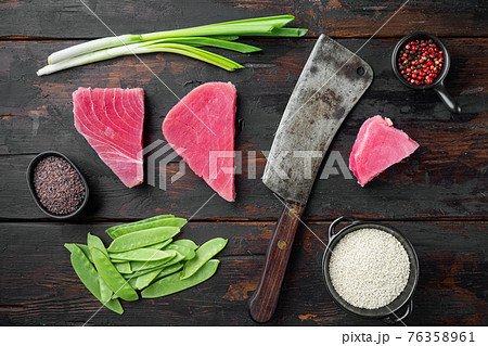 Raw tuna steak, fresh red tuna fillet with ingredients, green pea, sesame and spices, and old butcher cleaver knife, on old dark wooden table background, top view flat lay 76358961
