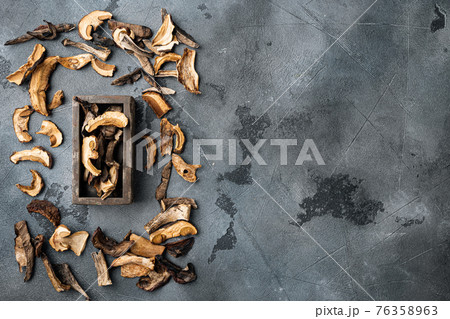 Dried wild mushrooms, on gray background, top view flat lay , with space for text copyspace Dried wild mushrooms, on gray background, top view flat lay , with space for text copyspace 76358963