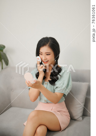 Young woman applying cosmetics powder. 76361061