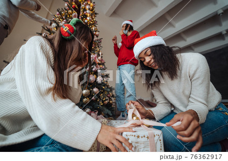 Beautiful girl exchange gifts for the new year. 76362917