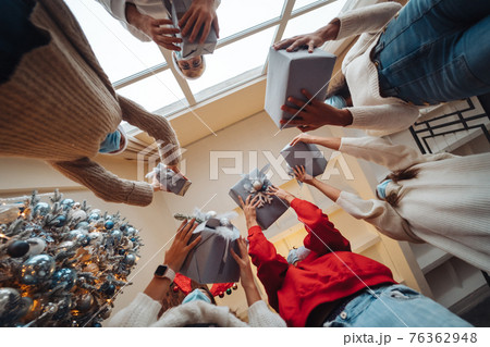 Multi-ethnic friends throwing their Christmas gifts in the air. Multi-ethnic friends throwing their Christmas gifts in the air. 76362948