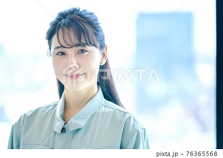 オフィスビルで働く作業服を着た若い女性 オフィスビルで働く作業服を着た若い女性 76365568