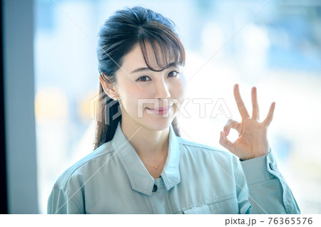 オフィスビルで働く作業服を着た若い女性 オフィスビルで働く作業服を着た若い女性 76365576