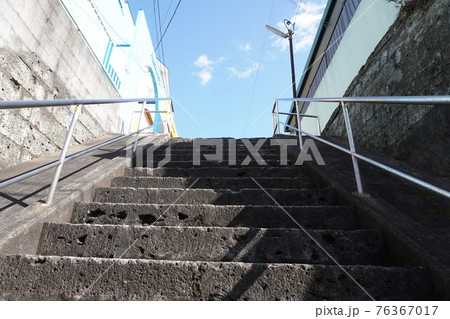 横浜市の坂の多い住宅街にあるコンクリート製の階段と青空の写真素材