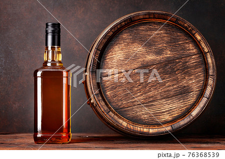 Scotch whiskey bottle and old barrel Scotch whiskey bottle and old barrel 76368539