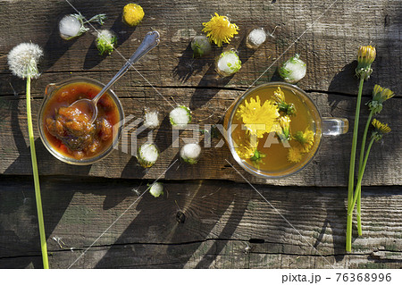 Medicinal Tea from dandelion in  glass cup, honey dandelion  on wooden rustic  table 76368996