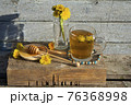 Medicinal Tea from dandelion in  glass cup with honey dandelion against a blue rustic wooden wall  with copy space 76368998
