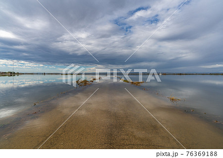 Flooded road under cloudy sky after the storm 76369188