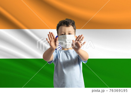 Little white boy in a protective mask on the background of the flag of India Makes a stop sign with his hands, stay at home India Little white boy in a protective mask on the background of the flag of India Makes a stop sign with his hands, stay at home India 76369195