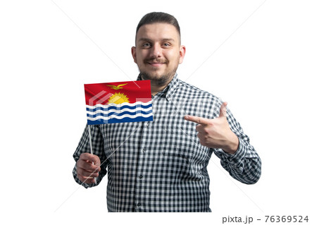 White guy holding a flag of Kiribati and points the finger of the other hand at the flag isolated on a white background White guy holding a flag of Kiribati and points the finger of the other hand at the flag isolated on a white background 76369524