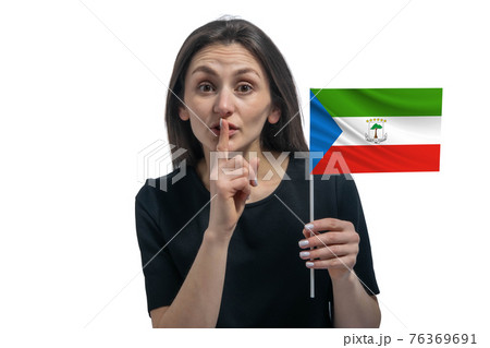 Happy young white woman holding flag of Equatorial Guinea and holds a finger to her lips isolated on a white background 76369691