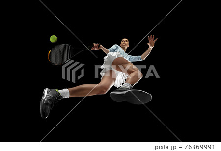 Female professional tennis player in action, motion isolated on black background, look from the bottom. Concept of sport, movement, energy and dynamic. Female professional tennis player in action, motion isolated on black background, look from the bottom. Concept of sport, movement, energy and dynamic. 76369991