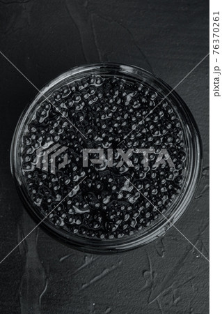 Black sturgeon caviar, on black background, top view flat lay Black sturgeon caviar, on black background, top view flat lay 76370261