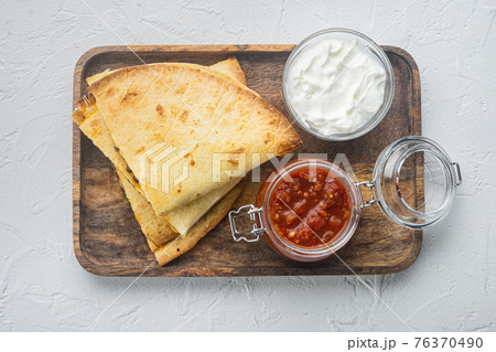 Spicy quesadilla made of tortilla with sauce and herbs, on white background, top view flat lay Spicy quesadilla made of tortilla with sauce and herbs, on white background, top view flat lay 76370490