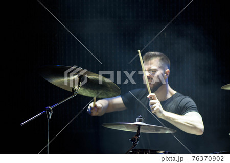 Silhouette drummer on stage. Dark background, smoke spotlights. Silhouette drummer on stage. Dark background, smoke spotlights. 76370902