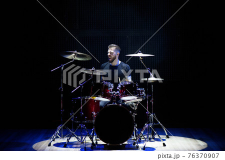 Silhouette drummer on stage. Dark background, smoke spotlights. Silhouette drummer on stage. Dark background, smoke spotlights. 76370907