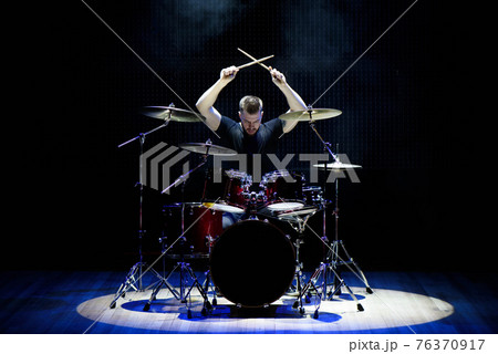 Drummer playing the drums with smoke and powder in the background. Drummer playing the drums with smoke and powder in the background. 76370917