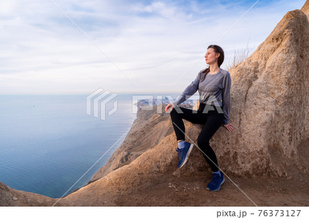 Woman looking on sunrise in the mountains 76373127