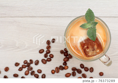Glass of delicious milkshake or smoothie with chocolate ice and leaves of mint. Glass of delicious milkshake or smoothie with chocolate ice and leaves of mint. 76373289