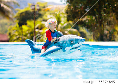 Child in swimming pool. Kid on inflatable float Child in swimming pool. Kid on inflatable float 76374845