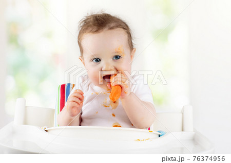 Baby eating vegetables. Solid food for infant. 76374956