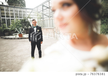Happy wedding couple walking in a botanical park 76376381