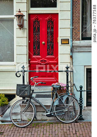 Bicycle near door of old house in Amsterdam street 76377588