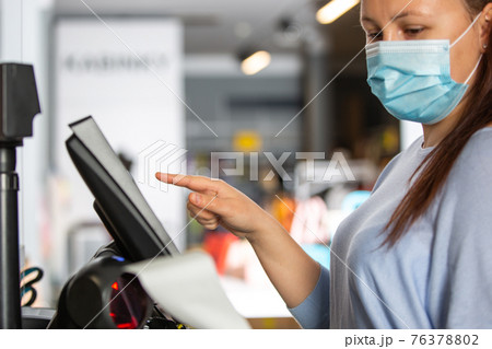 Saleswoman or shopgirl hands over the recepit or invoice by the shopping in the shop center, cloth sale concept 76378802